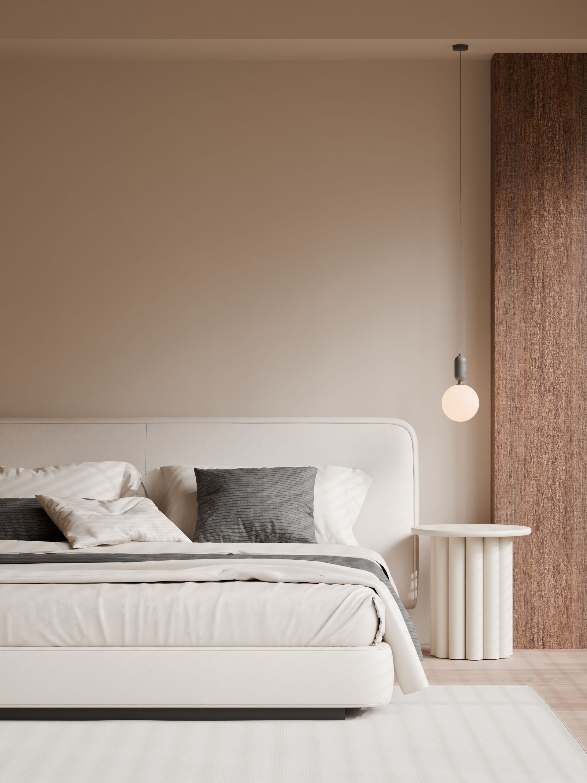 Chambre minimaliste beige avec un lit blanc, des coussins à motifs et une suspension.