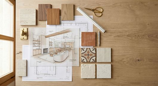 Plan d’architecte avec des échantillons de bois et de carrelage, des ciseaux et un crayon sur un bureau