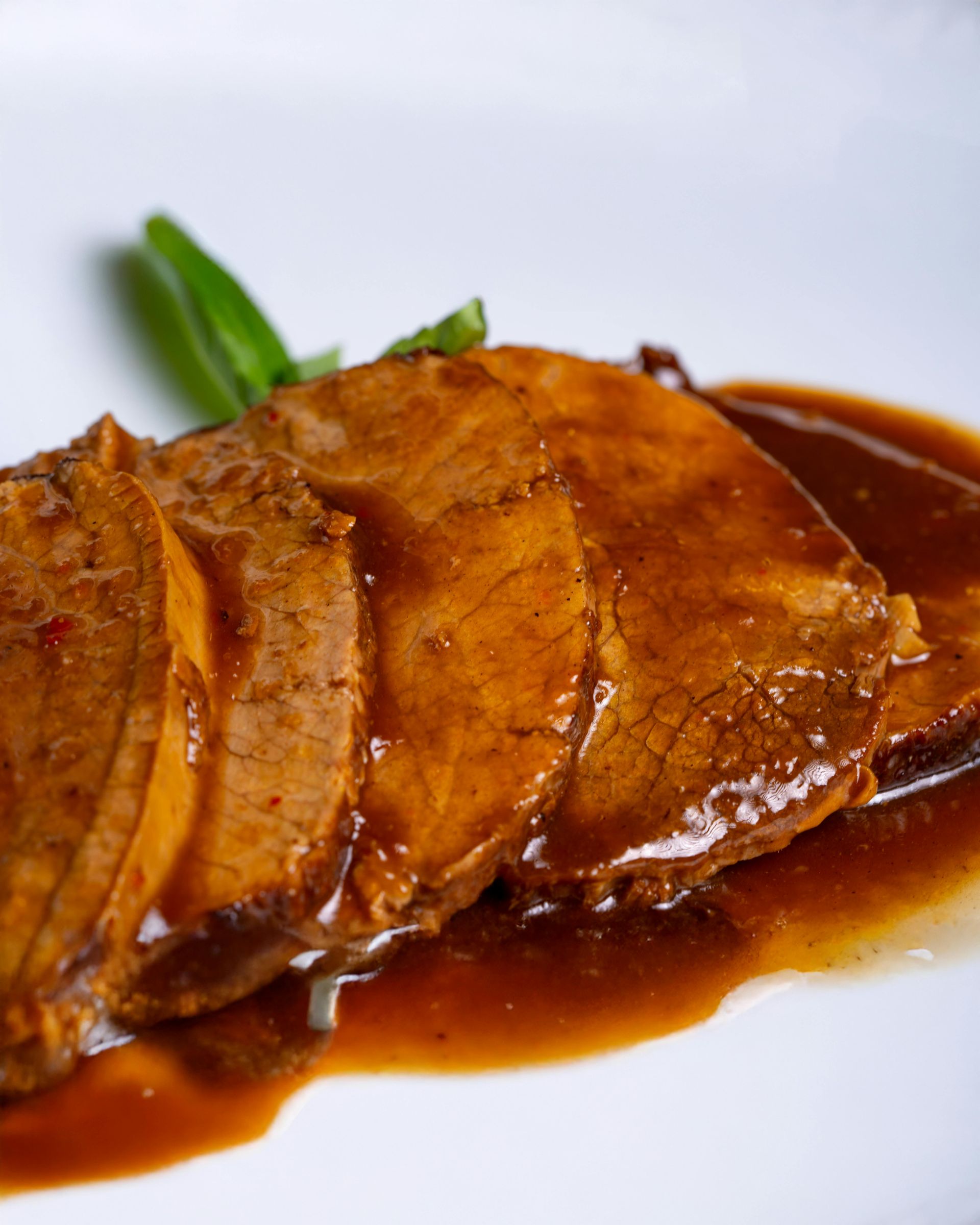 Herbstlicher Weg, gesäumt von Bäumen, bedeckt mit gefallenen gelben Blättern, in Sonnenlicht getaucht.