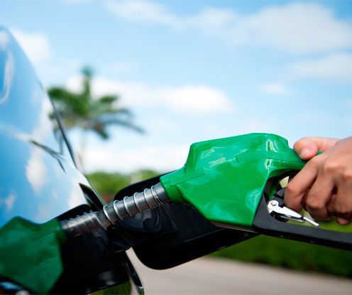 Una persona está cargando gasolina en un automóvil con una bomba de gasolina verde.