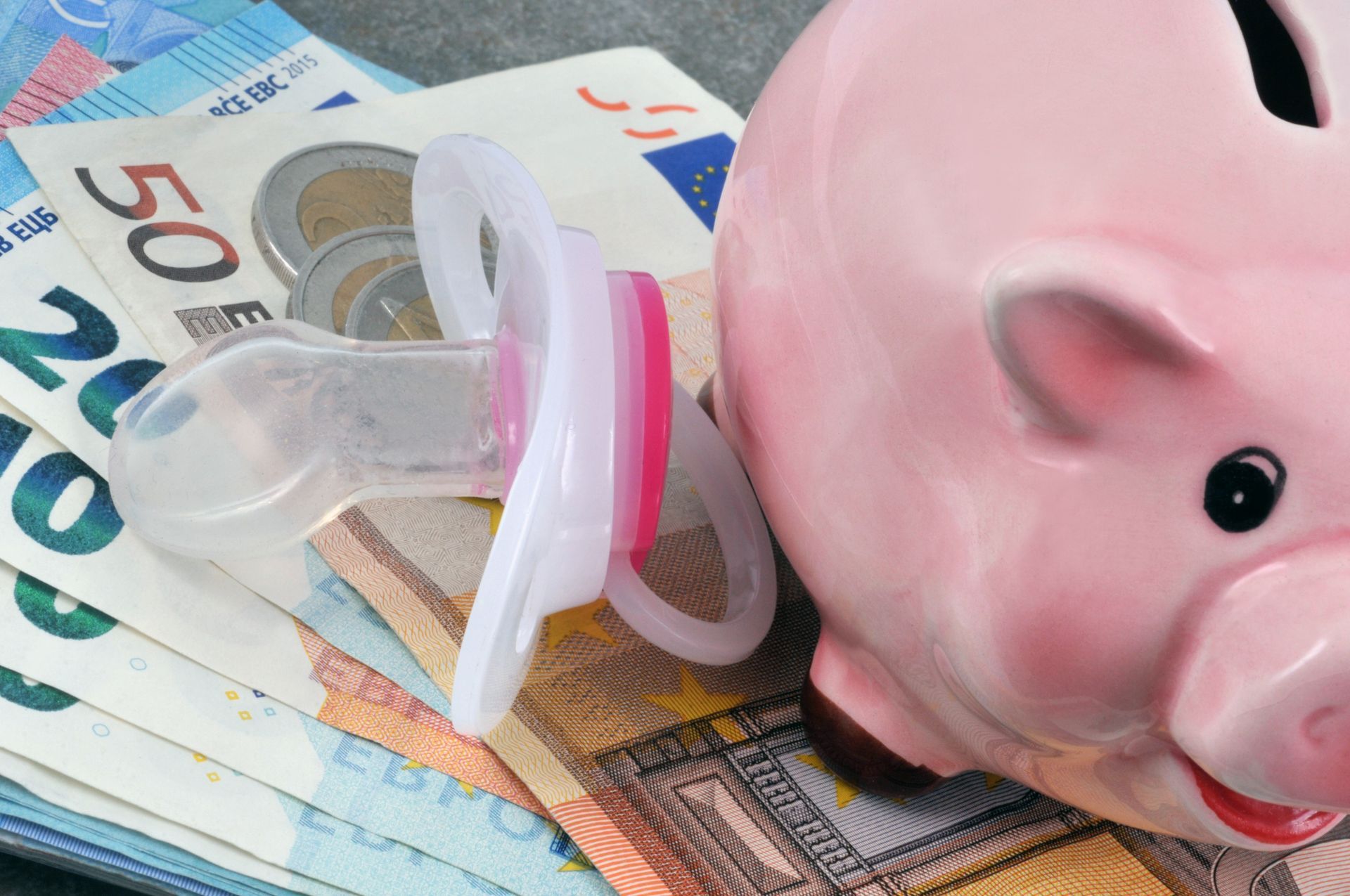 Tirelire, tétine et billets de banque