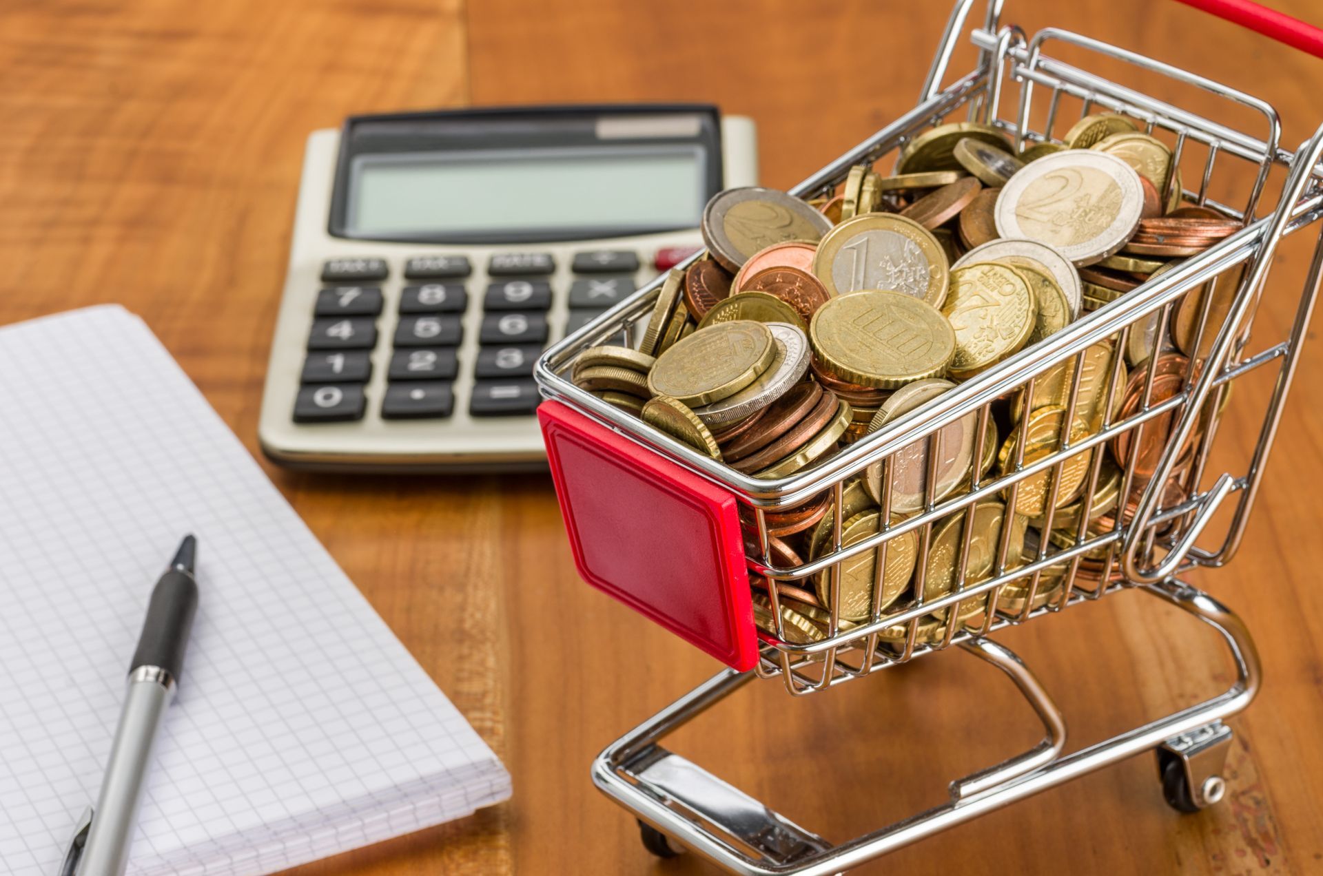 Caddie rempli de pièces de monnaie et calculatrice