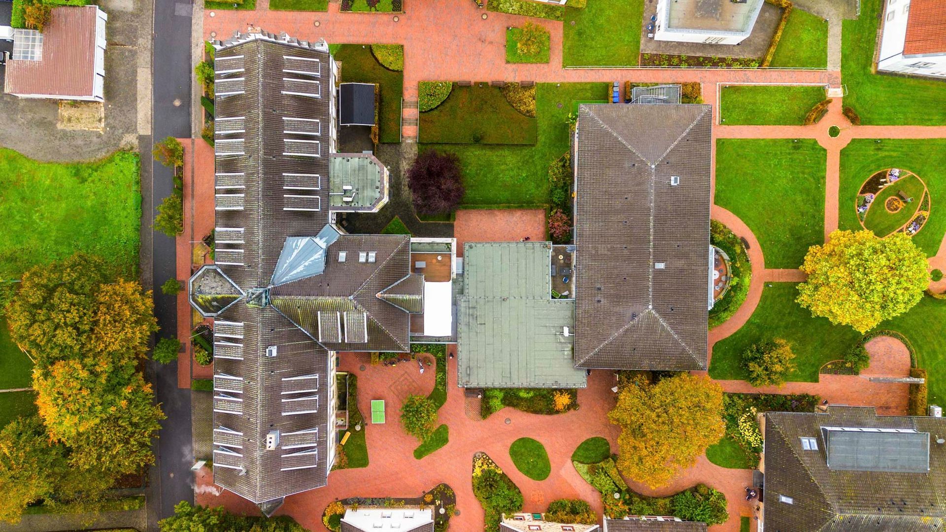 Fünf Personen posieren im Freien vor einem weißen Gebäude. Sie lächeln.