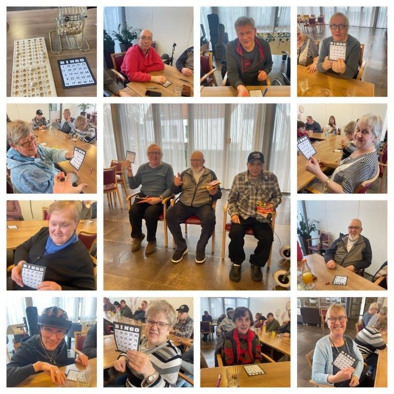 Menschen spielen Bingo in einem hell erleuchteten Raum. Die Spieler zeigen lächelnd ihre Karten. Die Bingokarten sind gut zu sehen.