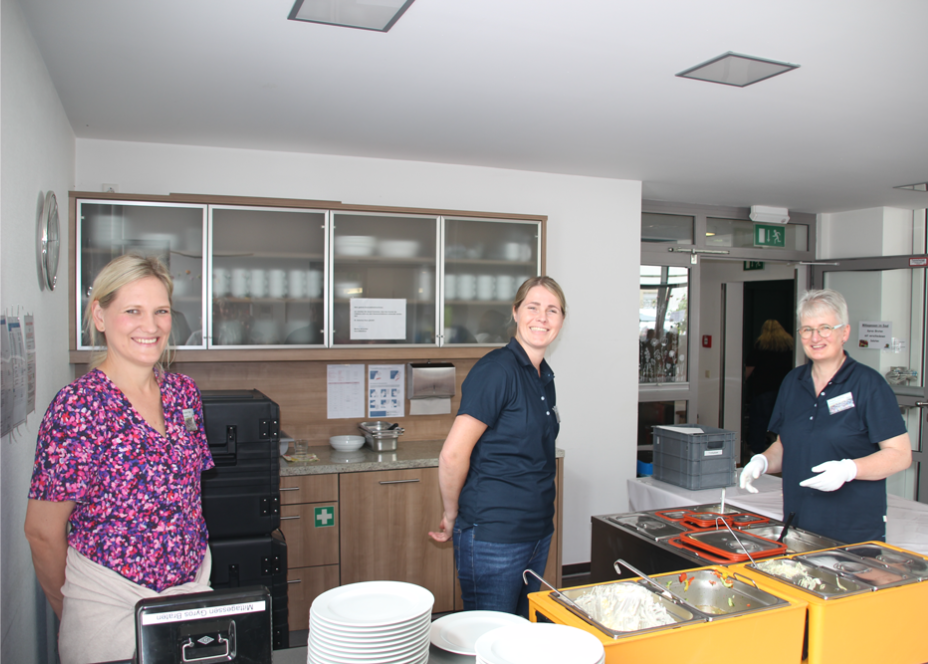 Ein Mann kauft in einer hell erleuchteten Umgebung Essen von einer Frau hinter einer Essenstheke.