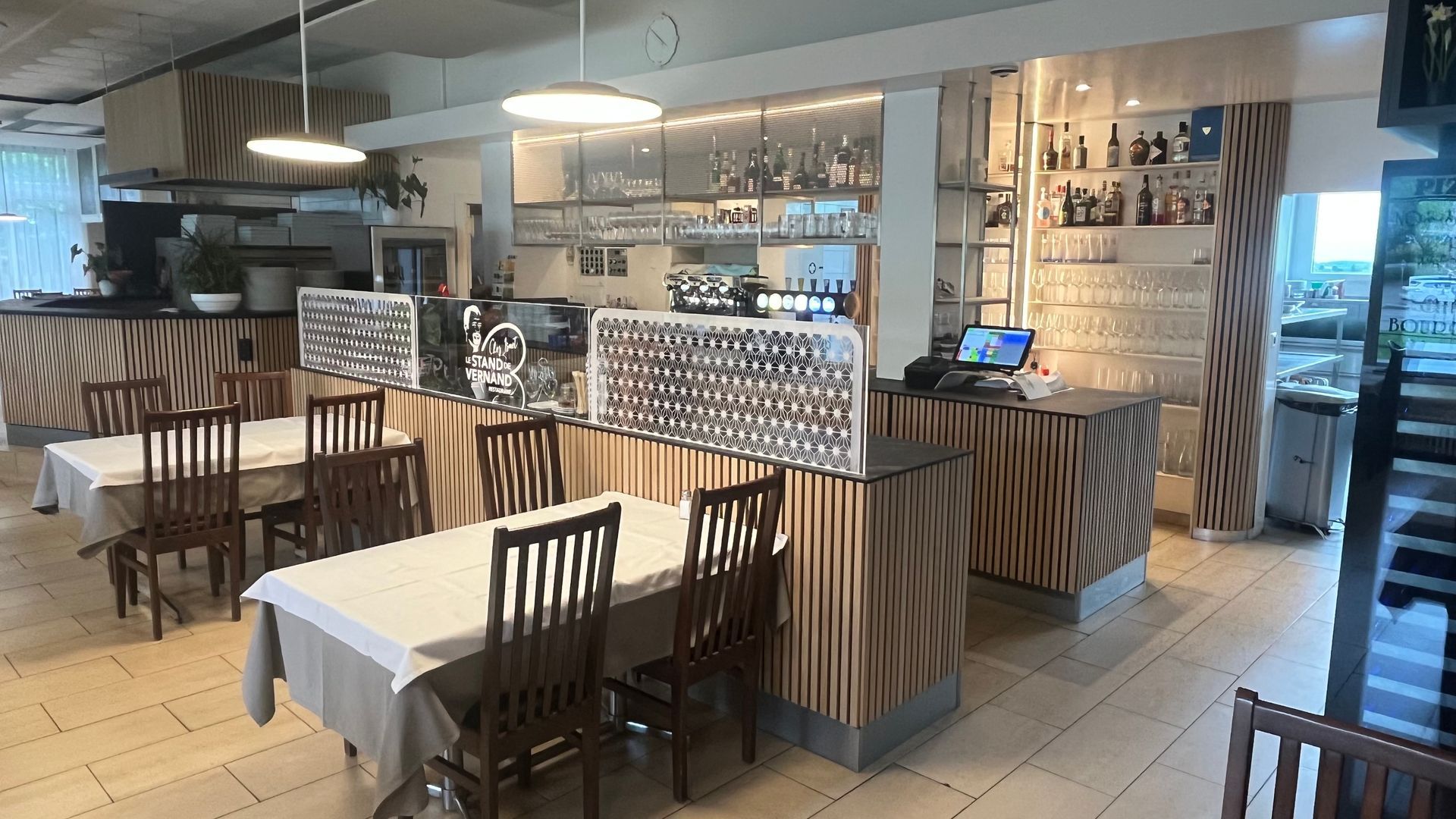 Un restaurant avec tables et chaises et un bar.