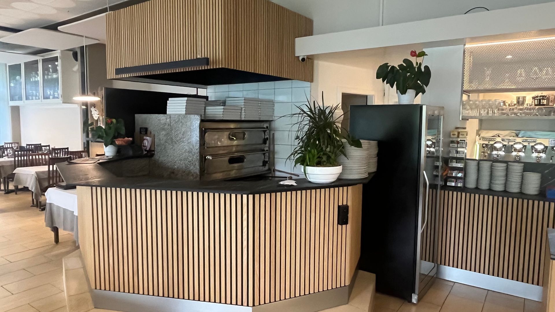 Un restaurant avec un comptoir en bois et un four à pizza.