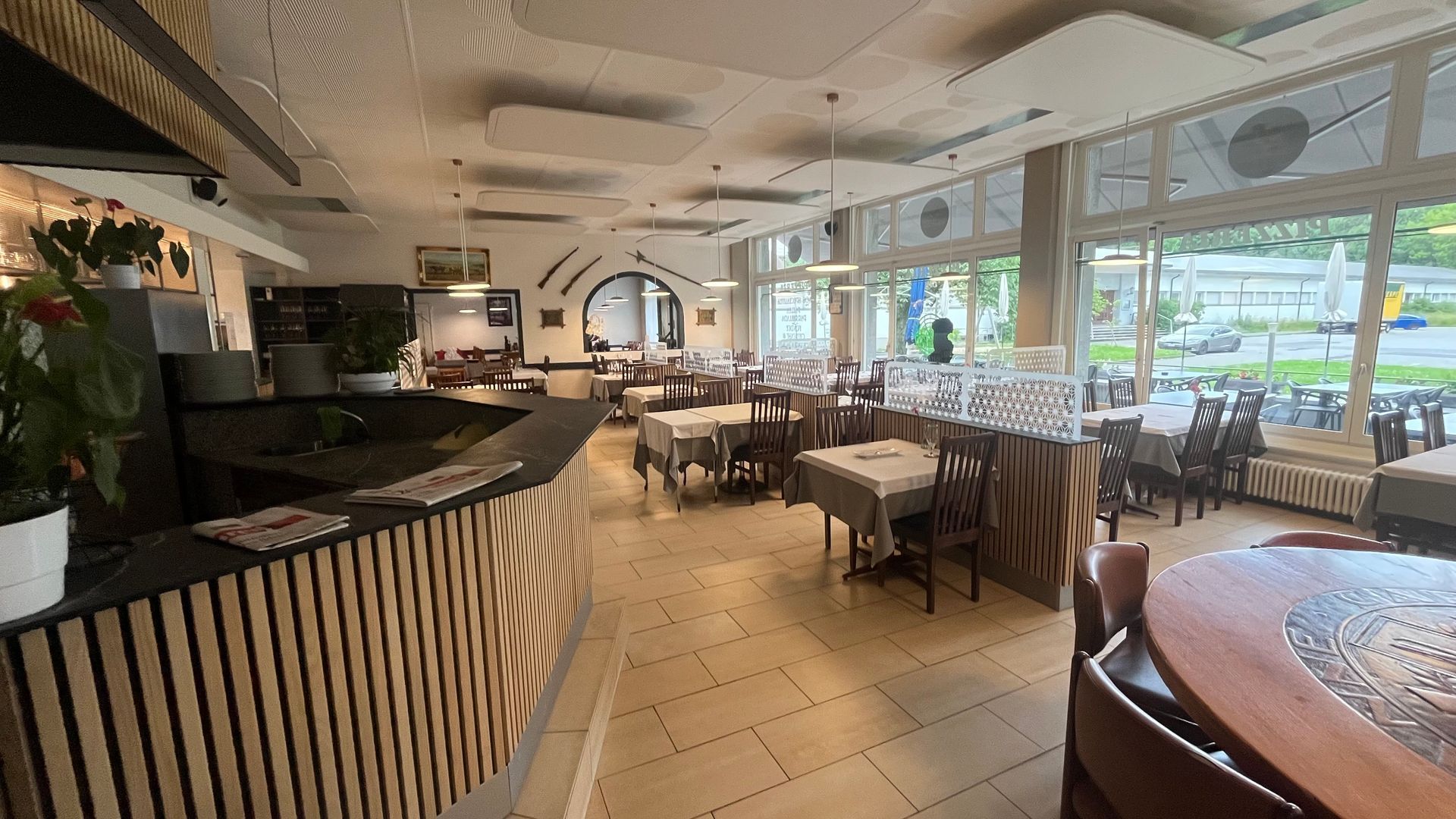 Une grande salle à manger avec tables et chaises et un bar.