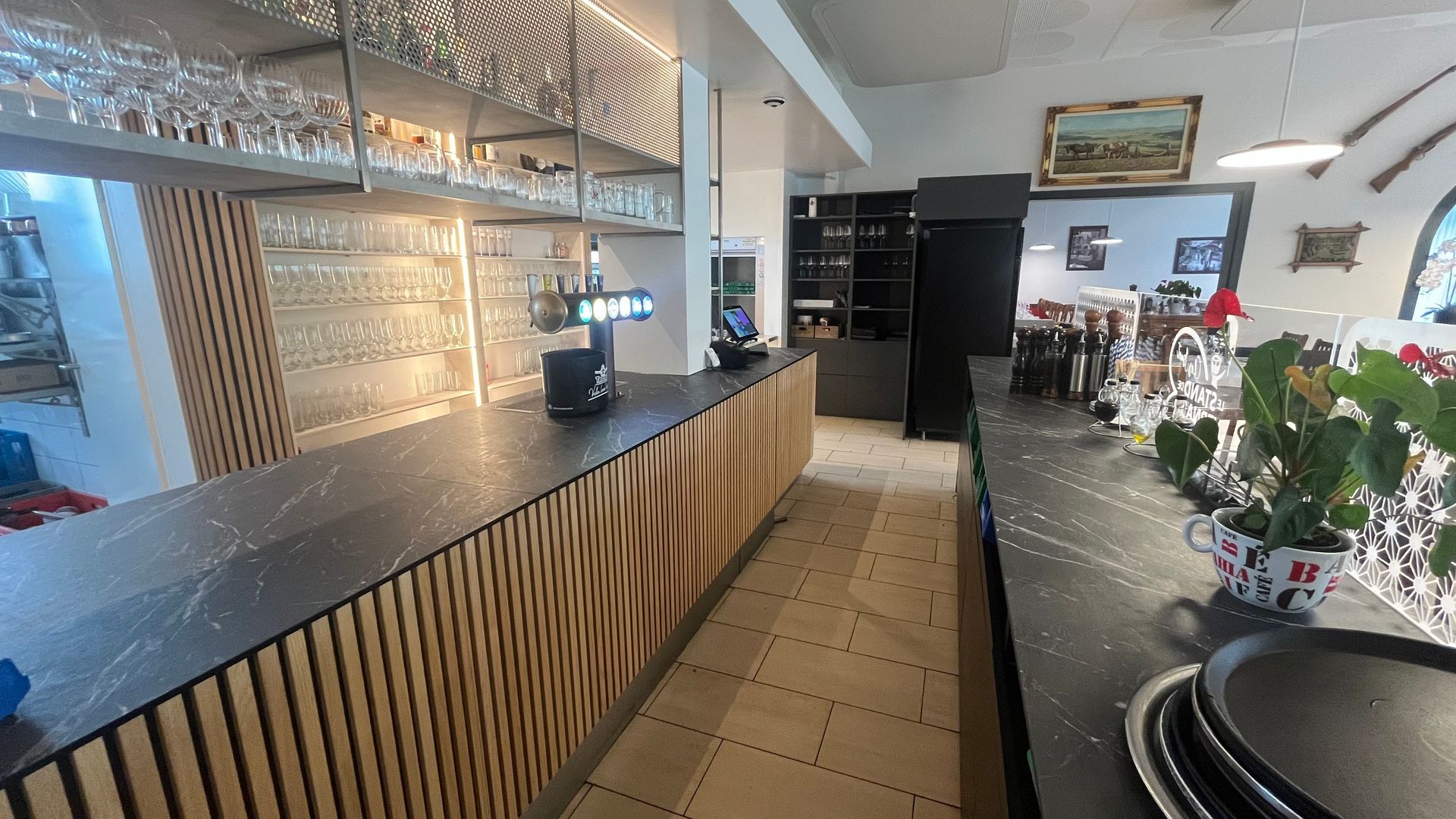 Un long comptoir dans un restaurant avec beaucoup de verres dessus.