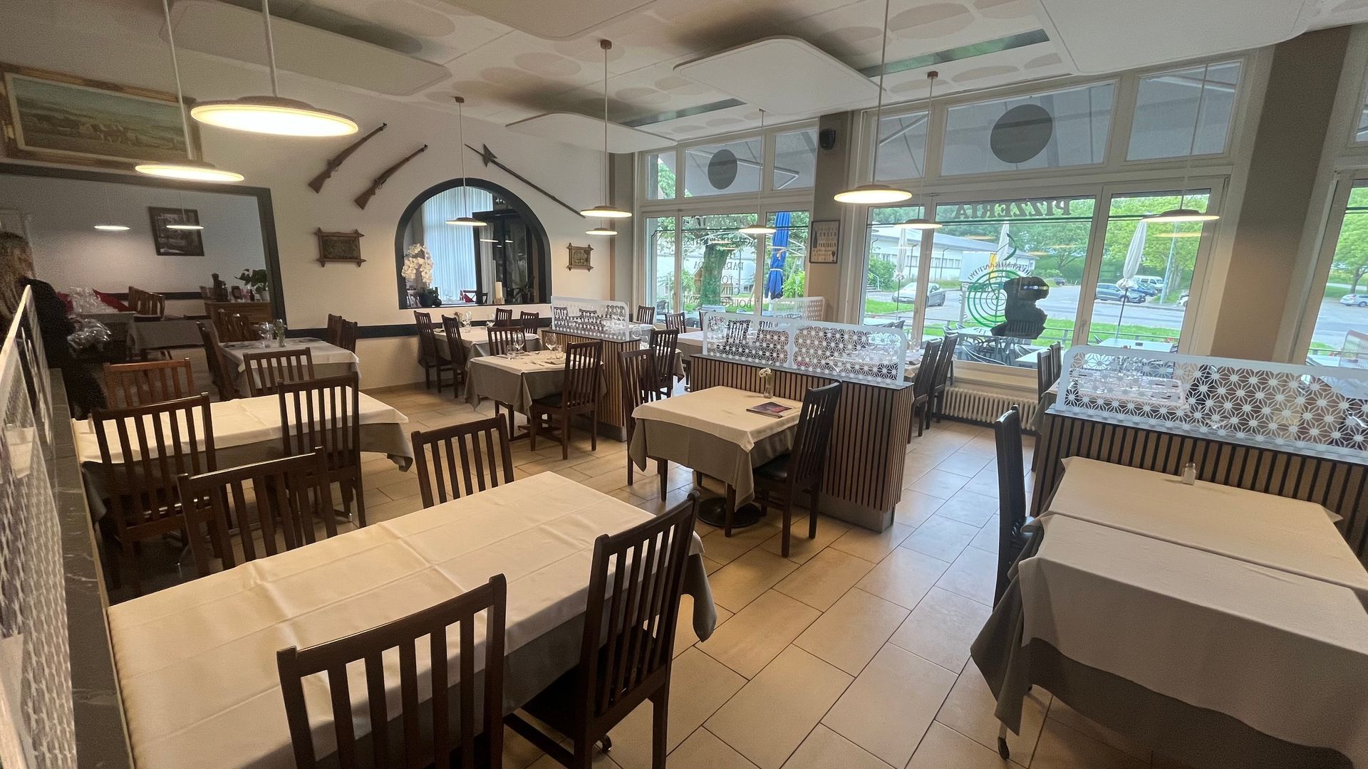 Un restaurant avec des tables et des chaises et beaucoup de fenêtres.