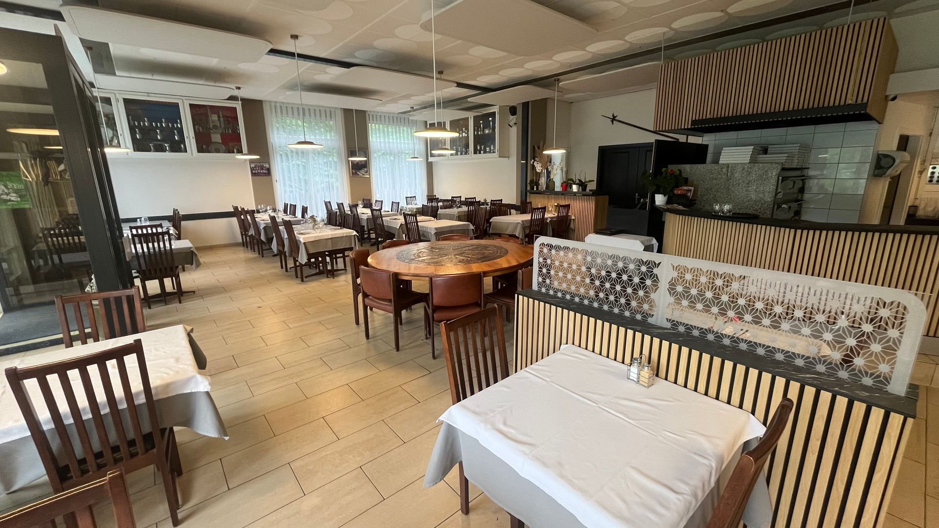 Une grande salle à manger avec tables et chaises dans un restaurant.