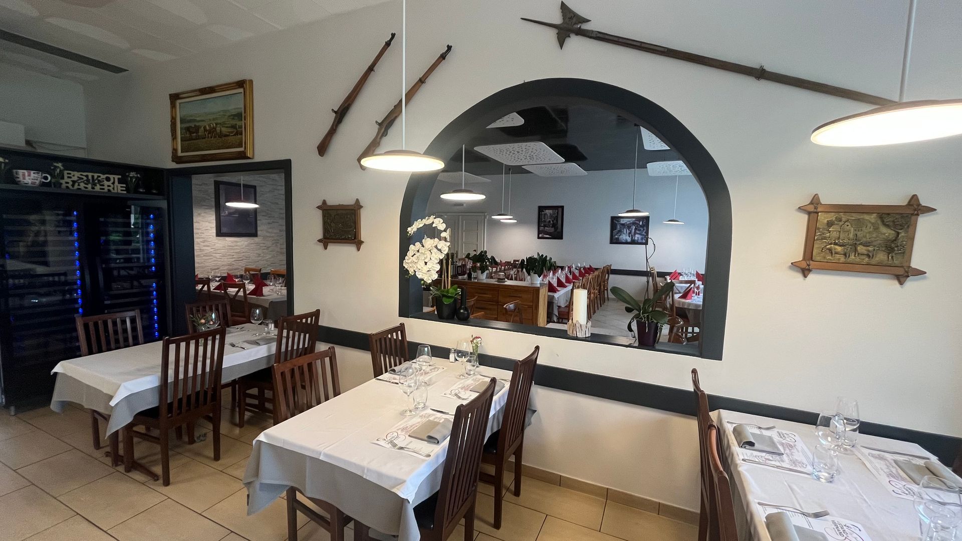 Un restaurant avec des tables et des chaises et un réfrigérateur Pepsi.