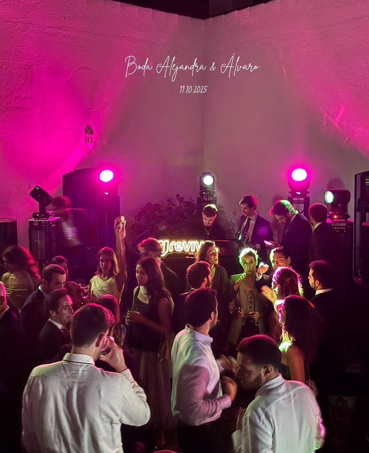 Pista de baile abarrotada en una fiesta, iluminada por luces rosas y moradas, con la gente de cara a la cabina del DJ.
