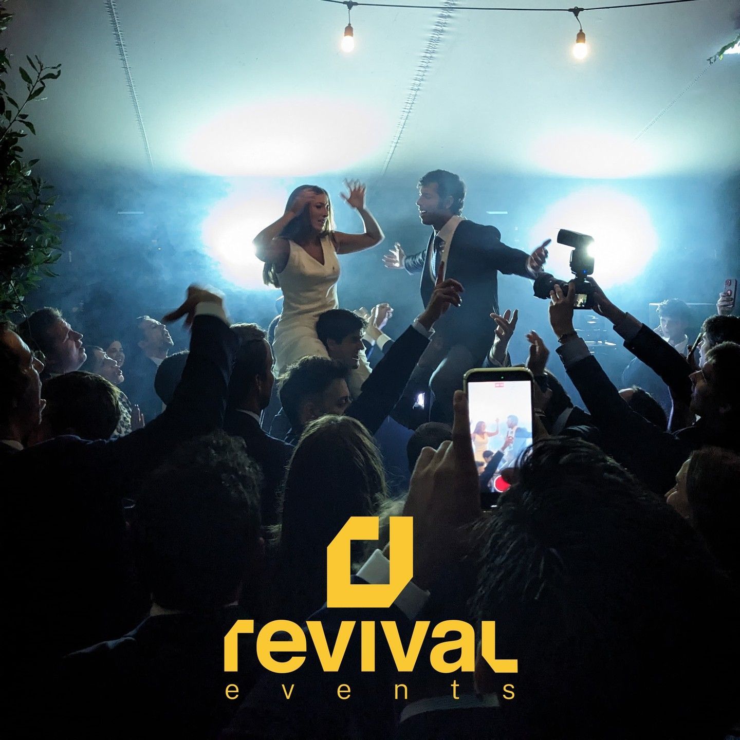 Público en un concierto en directo, con luces brillantes en el escenario y un cantante sobre el escenario; logotipo de «revival events» en la parte inferior