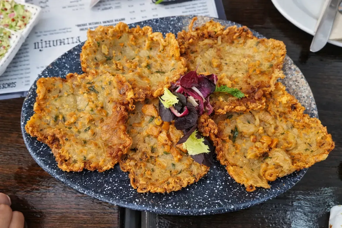 Comida frita en un plato azul moteado, adornado con lechuga.