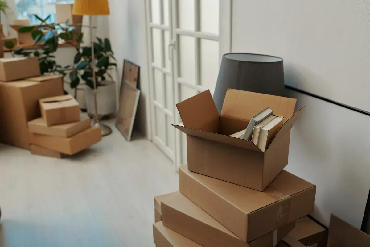 Cajas de cartón apiladas en una habitación, lo que indica una mudanza o embalaje.