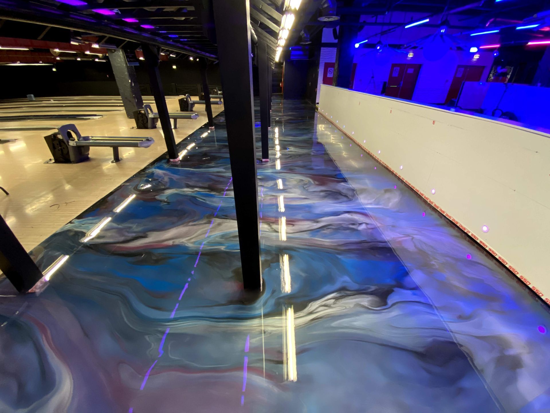 Une salle de bowling avec un sol bleu-noir