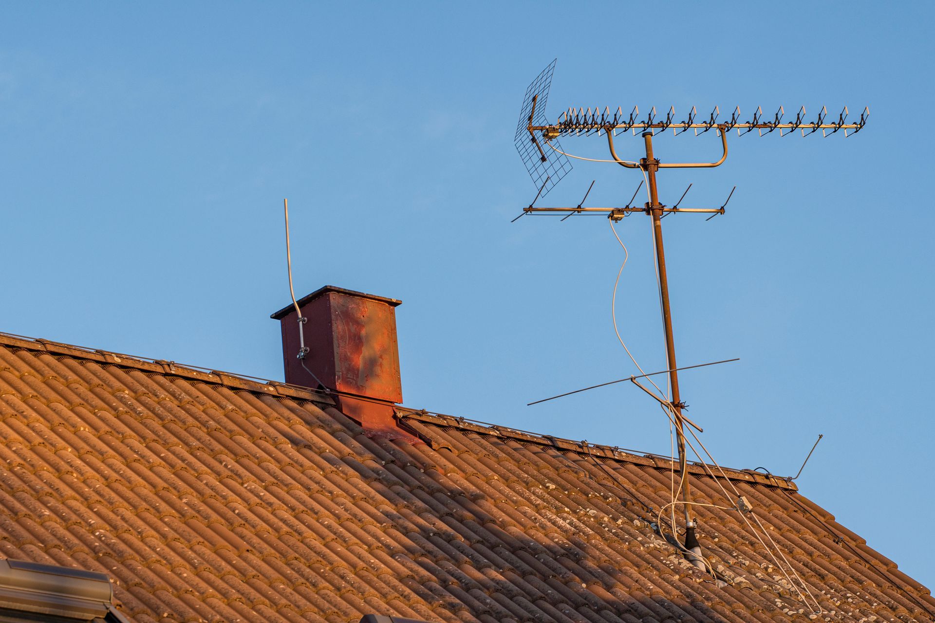 Une cheminée à côté d'une antenne de télévision