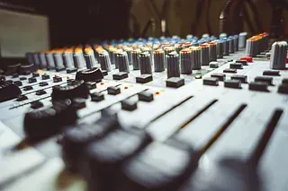 Consola de mezcla de audio con numerosos mandos y faders, utilizada en un estudio de grabación.