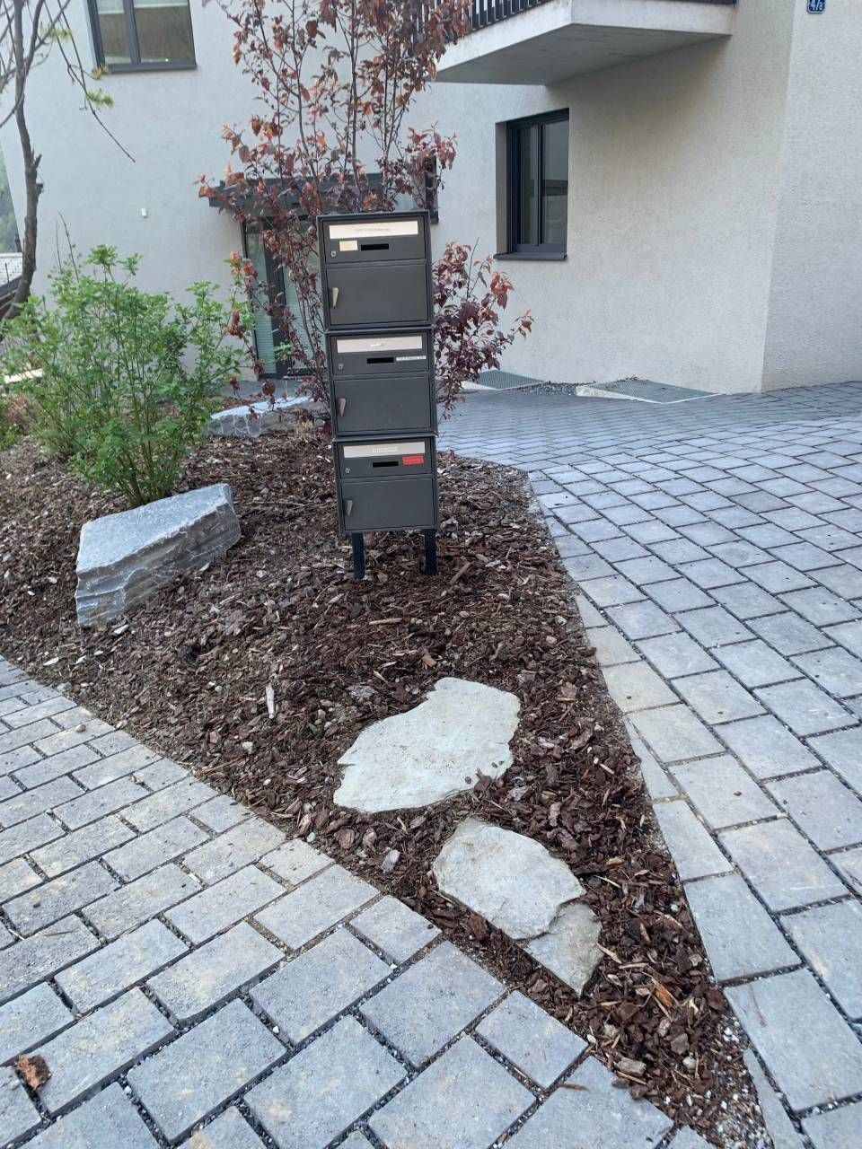 Une allée en briques avec une boîte aux lettres au milieu