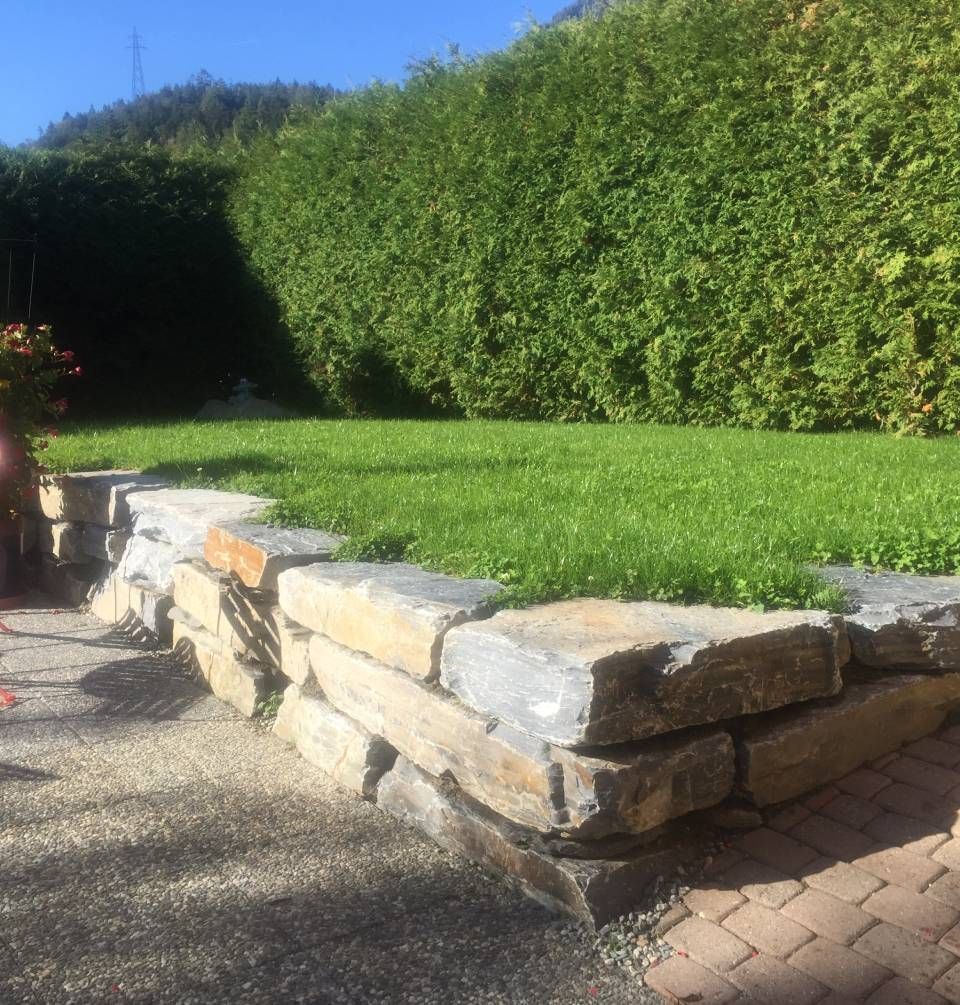 Un mur de pierre entoure une pelouse verte luxuriante