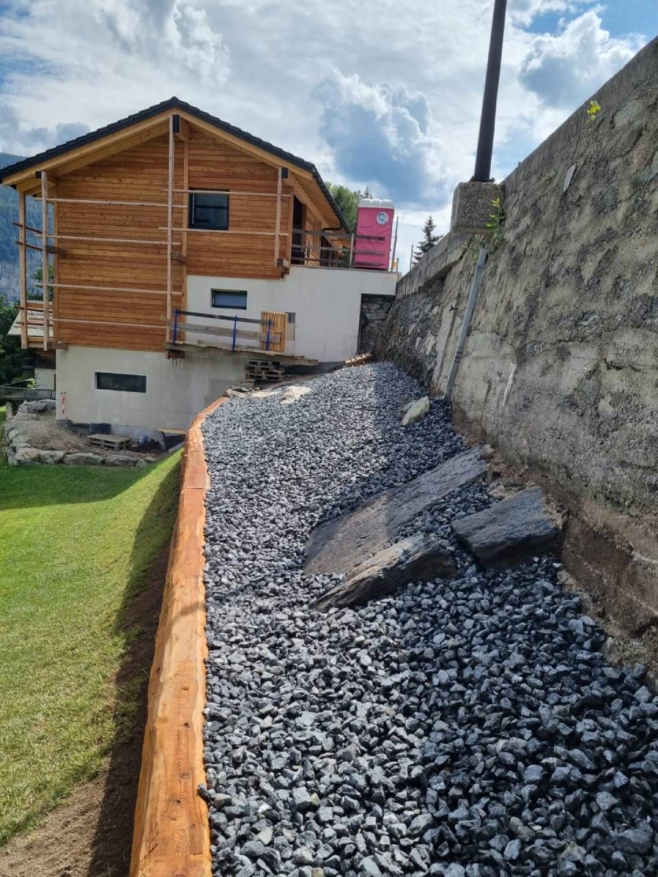 Une maison est en construction à côté d'un tas de gravier.