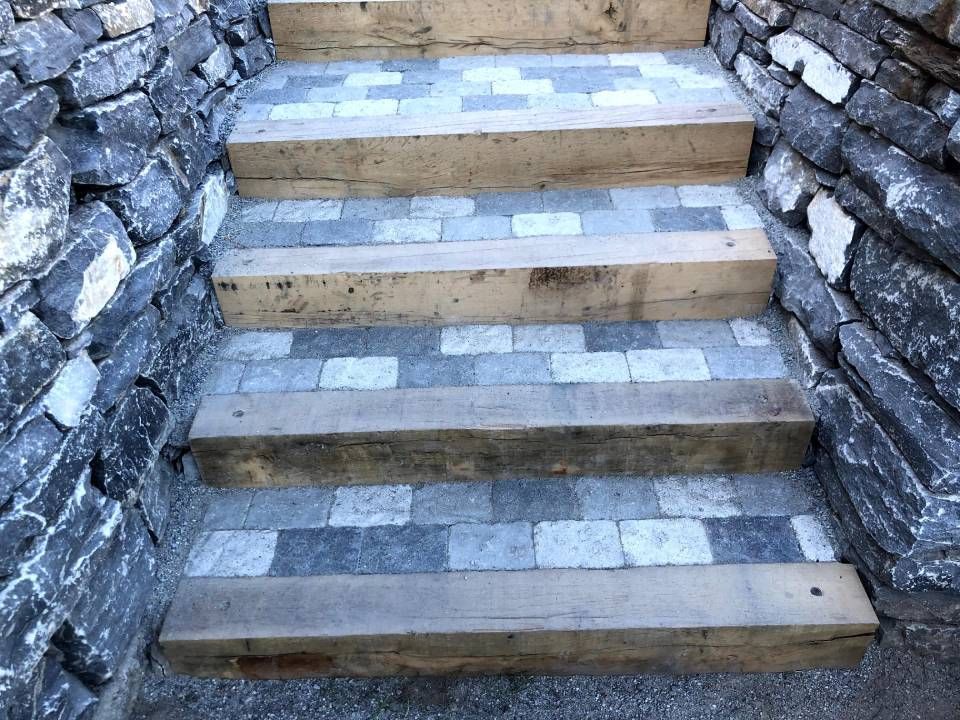 Un ensemble de marches en bois menant à un mur de pierre.