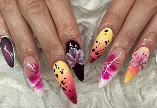 Un primer plano de las uñas de una mujer con diferentes diseños en ellas.