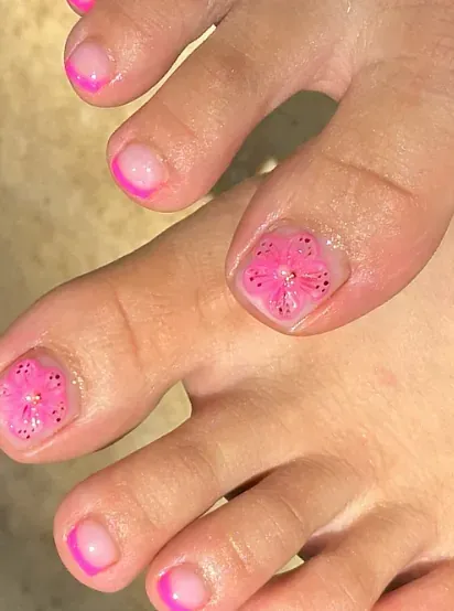 Un primer plano de los pies de una persona con uñas rosadas.