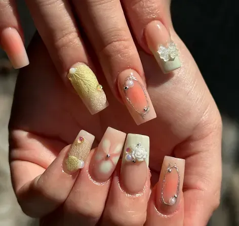 Un primer plano de las uñas de una mujer con un diseño floral.