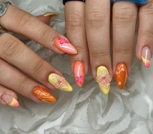 Un primer plano de las uñas de una persona con flores en ellas.