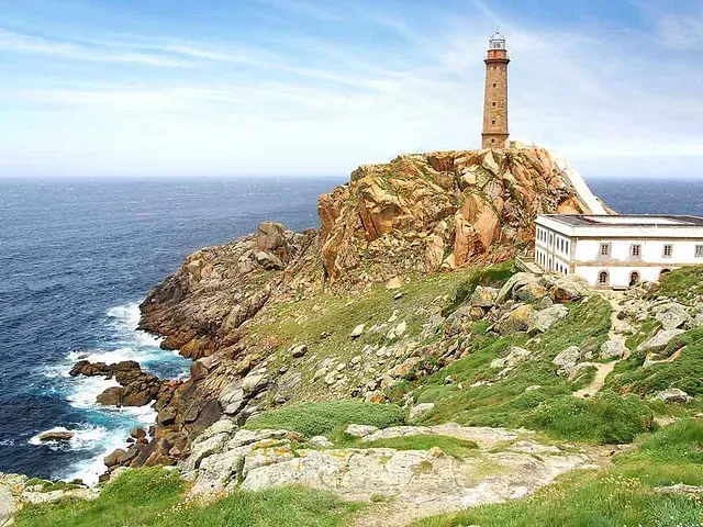 Un faro en lo alto de un acantilado con vistas al océano.