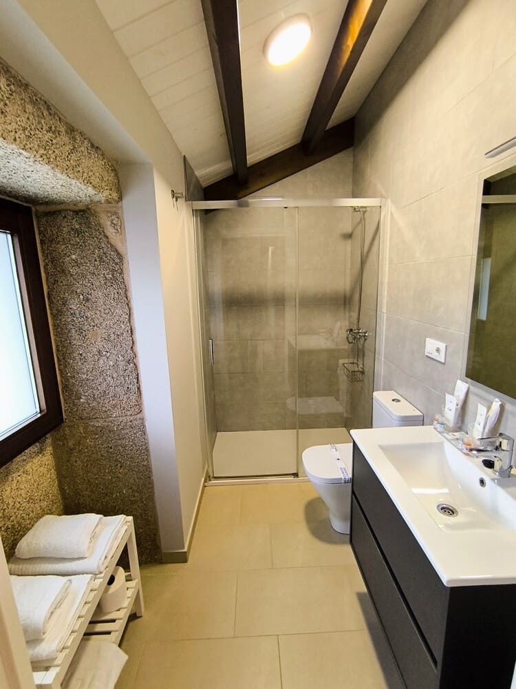 Un baño con lavabo, inodoro, ducha y espejo.