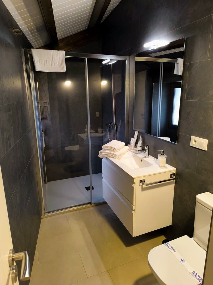 Un baño con inodoro, lavabo y ducha.