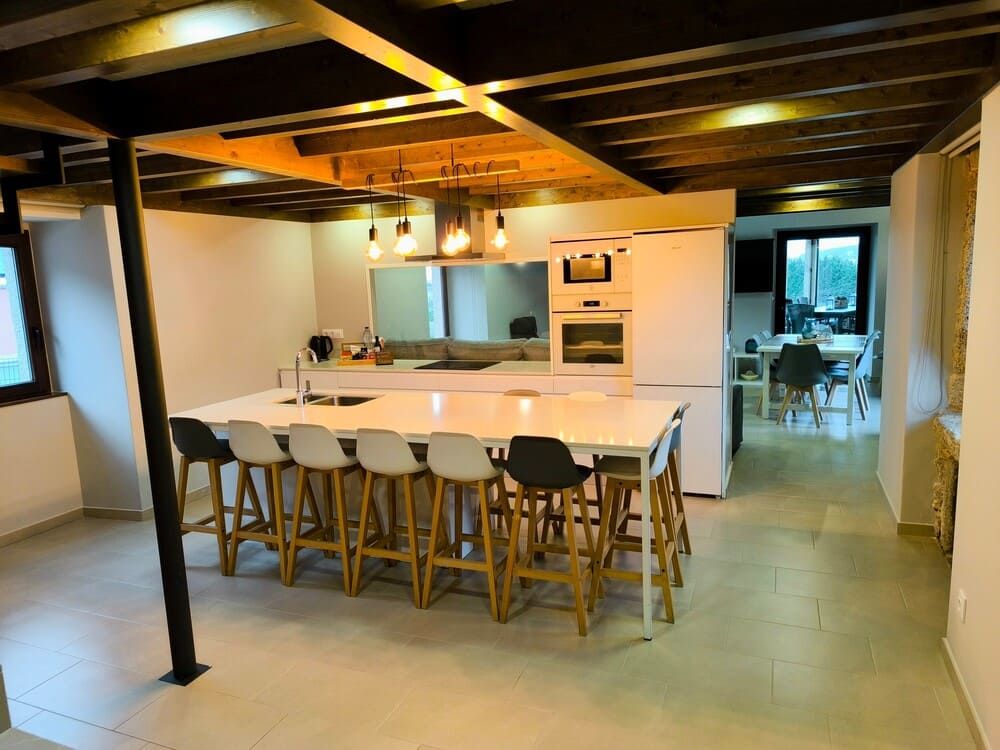 Una cocina grande con una mesa larga y taburetes.