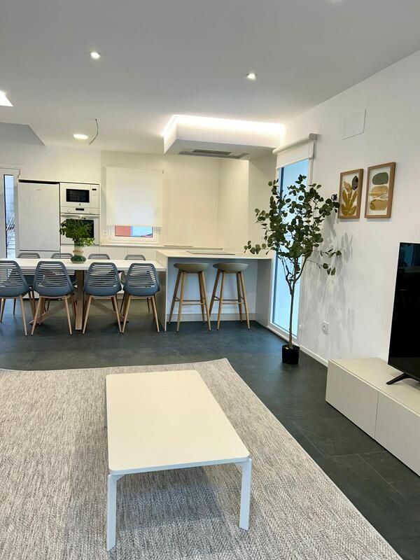 Una sala de estar con una mesa y sillas y un televisor.