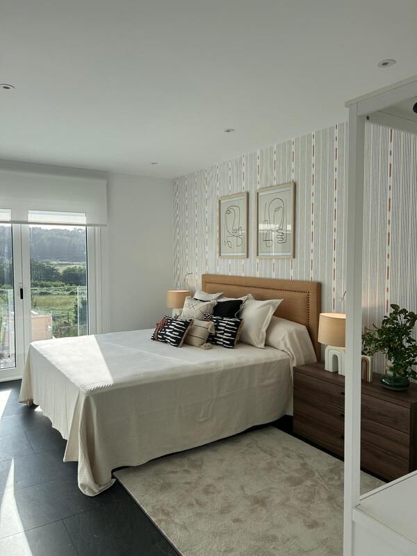 Un dormitorio con una cama grande y una ventana grande.