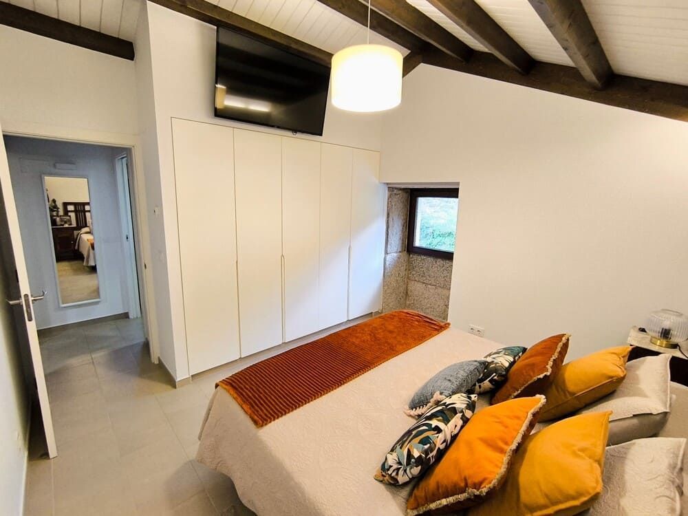 Un dormitorio con una cama grande, un sofá y una ventana.