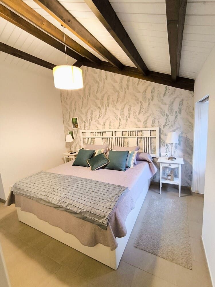 Un dormitorio con una cama grande y una mesita de noche.