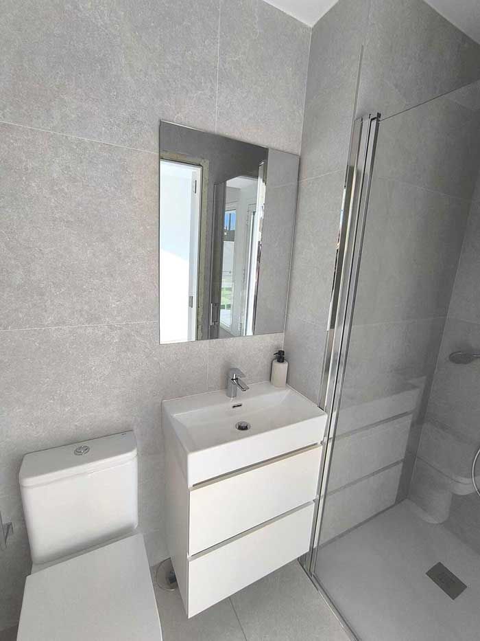 Un baño con inodoro, lavabo y espejo.