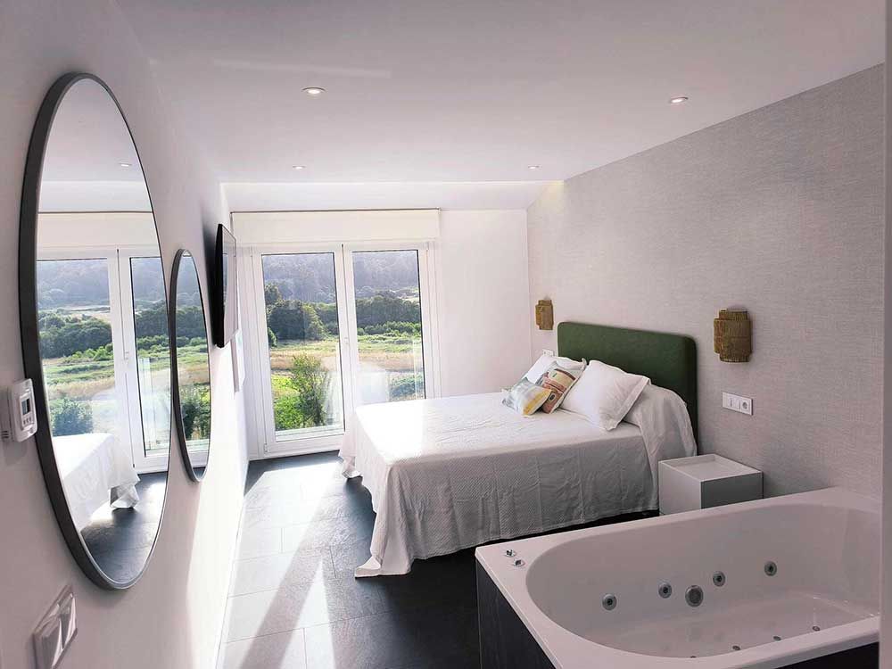 Un dormitorio con dos camas y bañera de hidromasaje.