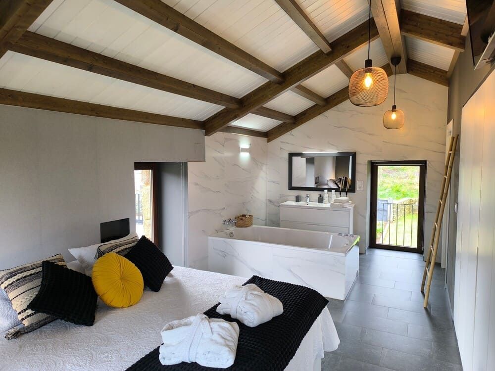 Un dormitorio con una cama y una bañera.