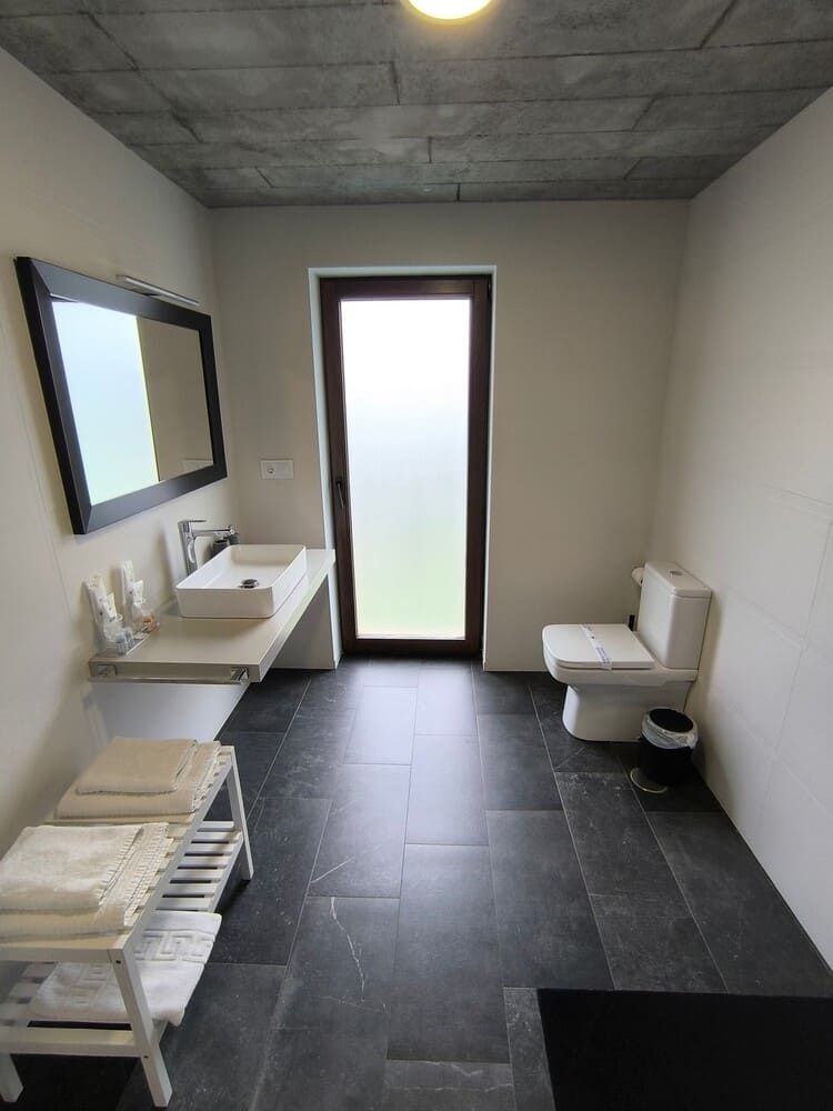 Un baño con inodoro, lavabo y espejo.