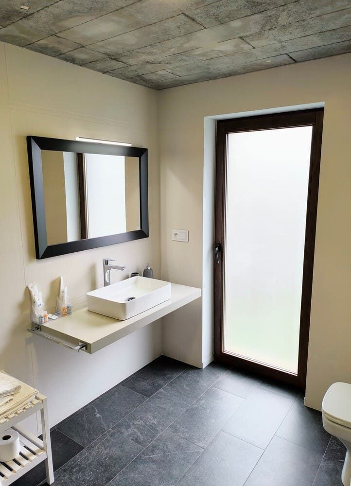 Un baño con lavabo, espejo e inodoro.