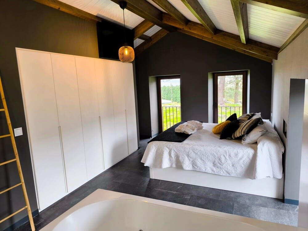 Un dormitorio con una cama grande y una bañera.