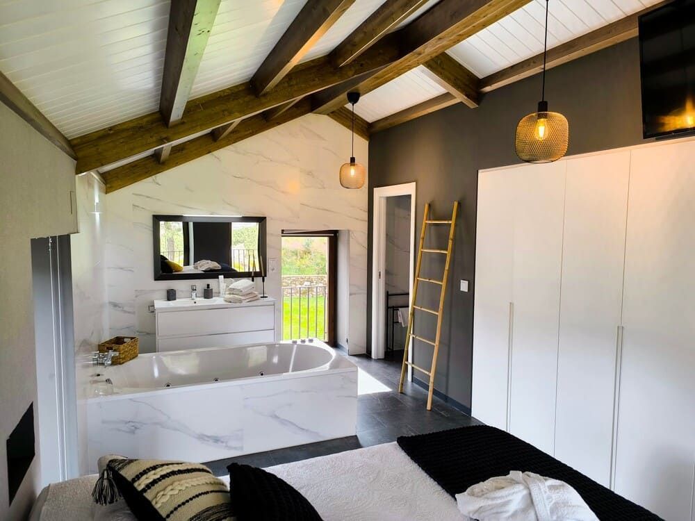 Un dormitorio con una cama grande y una bañera de hidromasaje.