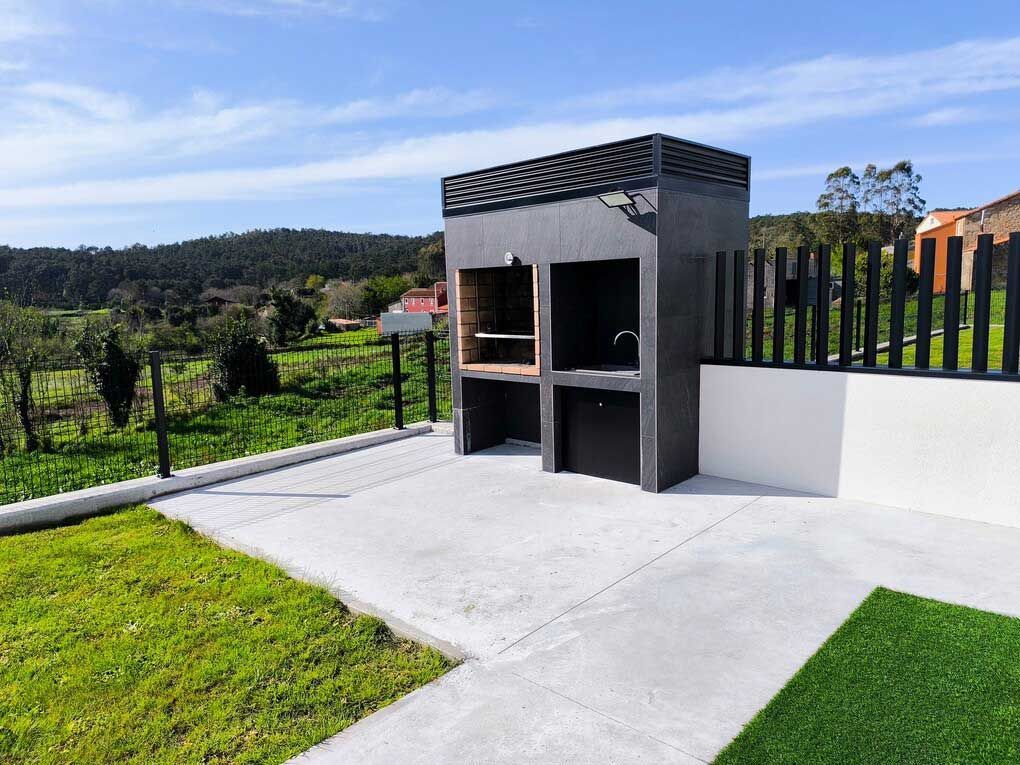 Un patio con parrilla y una reja al fondo.