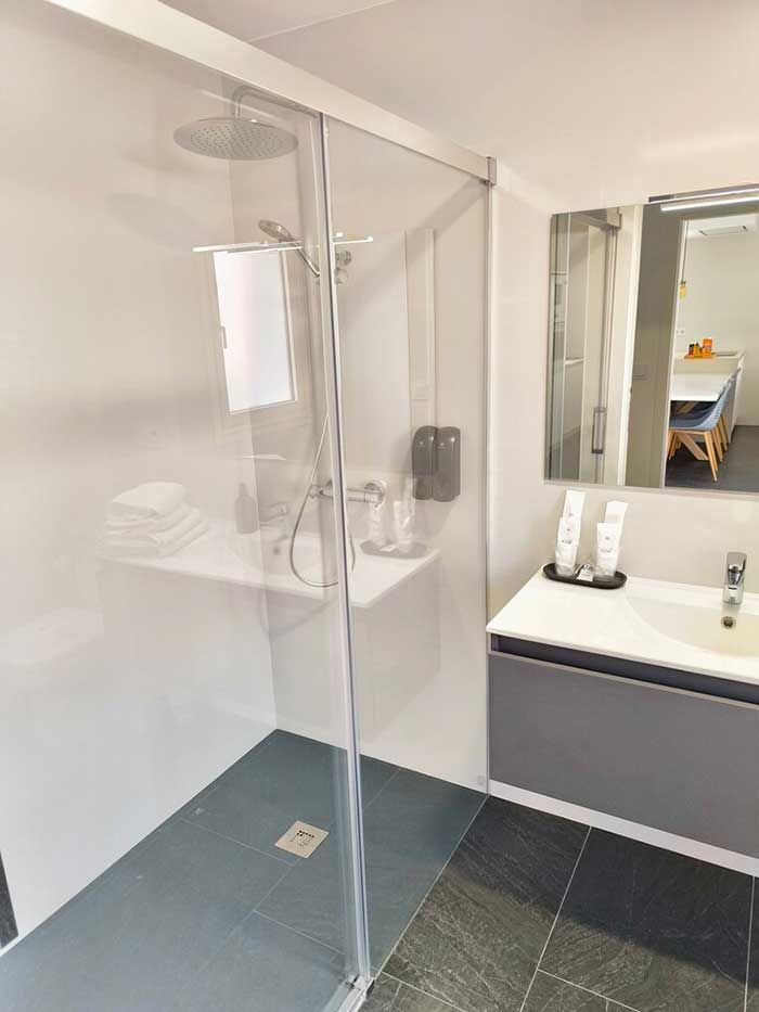 Un baño con ducha, lavabo y espejo.