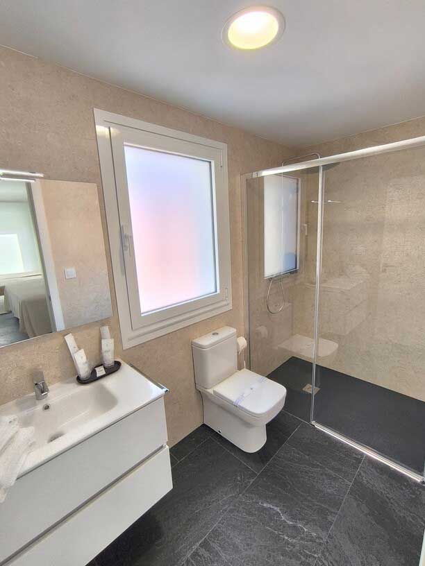 Un baño con inodoro, lavabo y ventana.