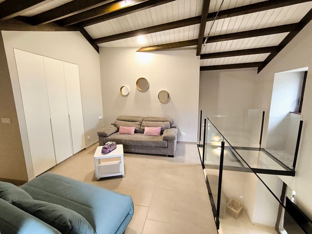 Una sala de estar con un sofá y escaleras que conducen al segundo piso.